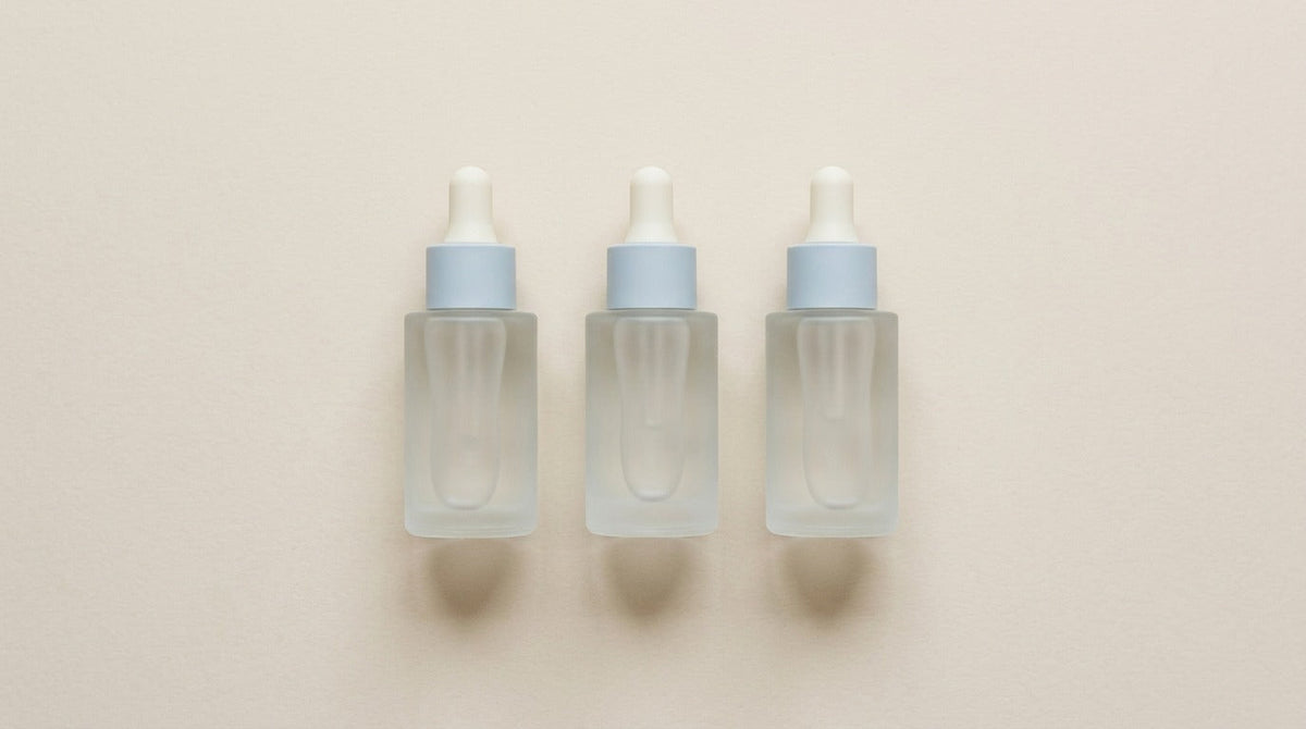 AI-generated image of three frosted glass dropper bottles on a neutral background